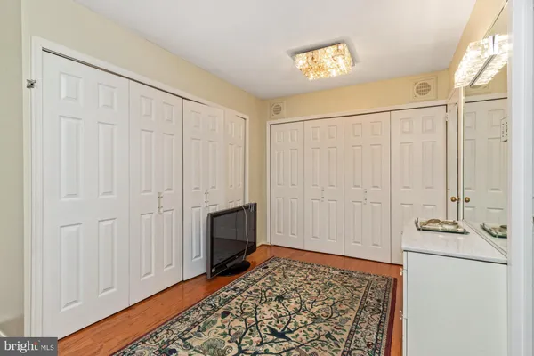 a view of a hallway with bathroom and wooden floor