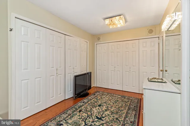 a view of a hallway with bathroom and wooden floor