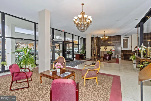 a living room with furniture a chandelier and a table