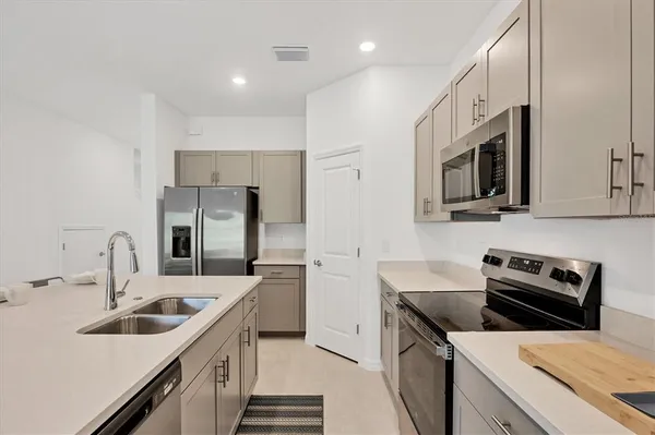 a kitchen with stainless steel appliances kitchen island granite countertop a stove a sink a dining table and chairs