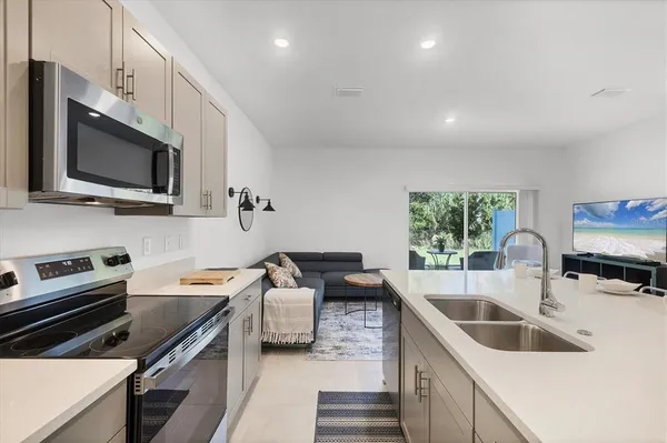 a kitchen with stainless steel appliances a sink stove and refrigerator