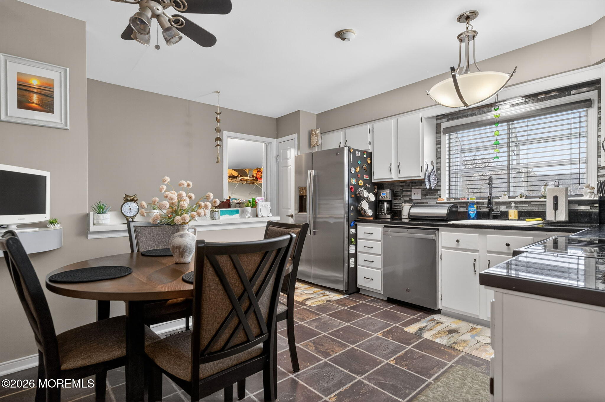 5 Scarborough Road, Unit D Monroe Township, NJ 08831 - Photo 8 of 28 a kitchen with stainless steel appliances kitchen island granite countertop a dining table chairs and a refrigerator