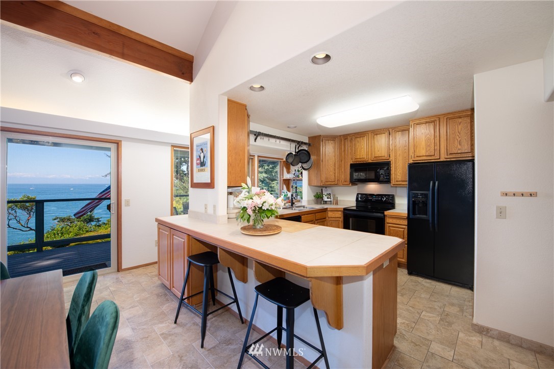 3115 Biz Point Road Anacortes, WA 98221 - Photo 11 of 39 a kitchen with stainless steel appliances kitchen island granite countertop a refrigerator a stove a microwave oven a sink with island and chairs