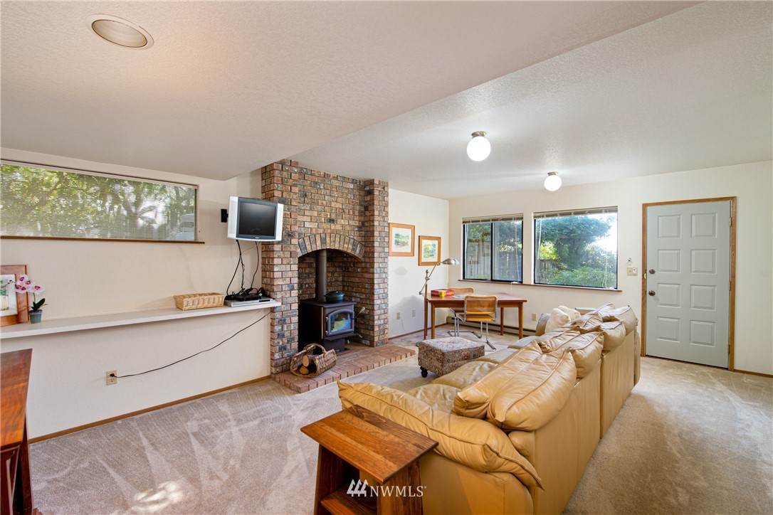 3115 Biz Point Road Anacortes, WA 98221 - Photo 29 of 39 a living room with furniture a fireplace and a window
