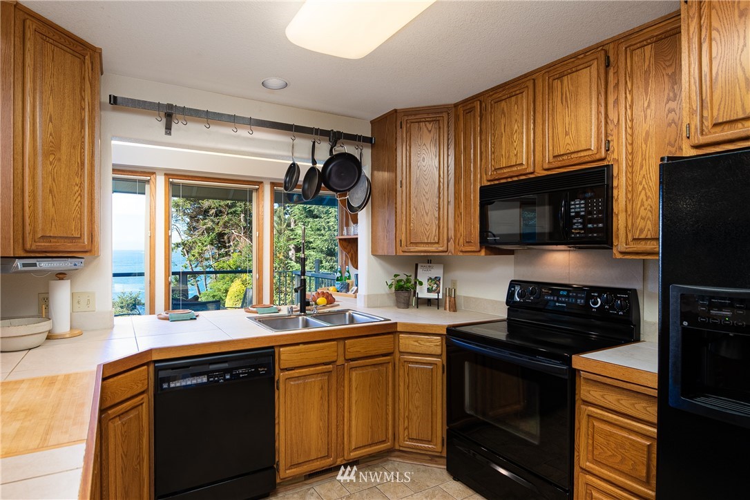 3115 Biz Point Road Anacortes, WA 98221 - Photo 30 of 39 a kitchen with granite countertop a sink cabinets stainless steel appliances and a window
