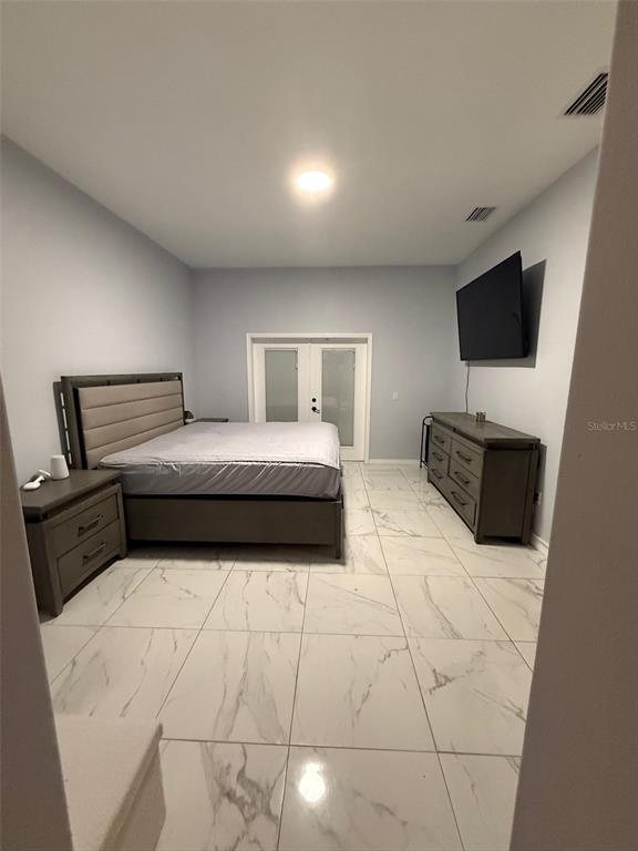 5690 Merlin Way St. Cloud, FL 34772 - Photo 17 of 46 a bedroom with a bed and flat screen tv