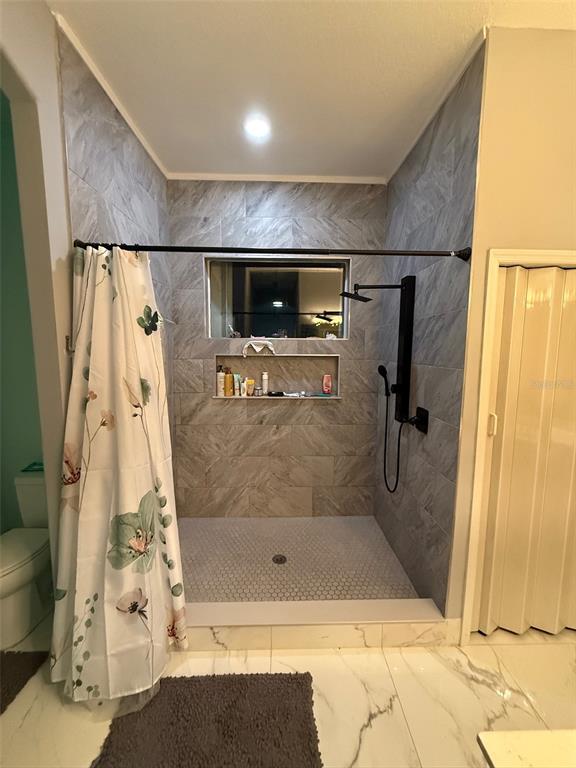 5690 Merlin Way St. Cloud, FL 34772 - Photo 20 of 46 a bathroom with a bathtub and a shower