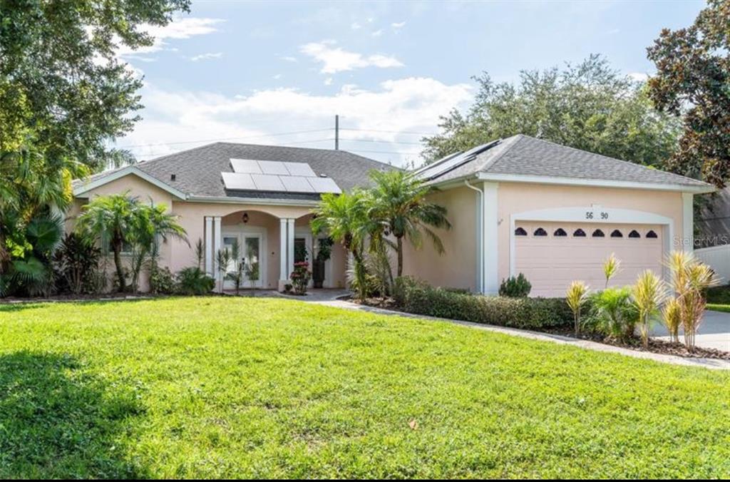 5690 Merlin Way St. Cloud, FL 34772 - Photo 2 of 46 a view of a white house with a big yard and potted plants