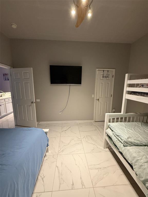 5690 Merlin Way St. Cloud, FL 34772 - Photo 26 of 46 a bedroom with a bed and a television