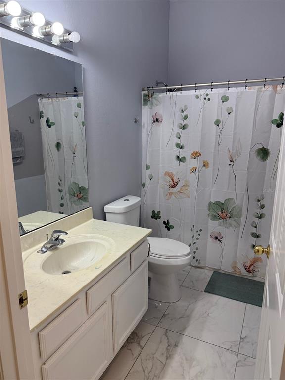 5690 Merlin Way St. Cloud, FL 34772 - Photo 34 of 46 a bathroom with a sink a toilet and shower