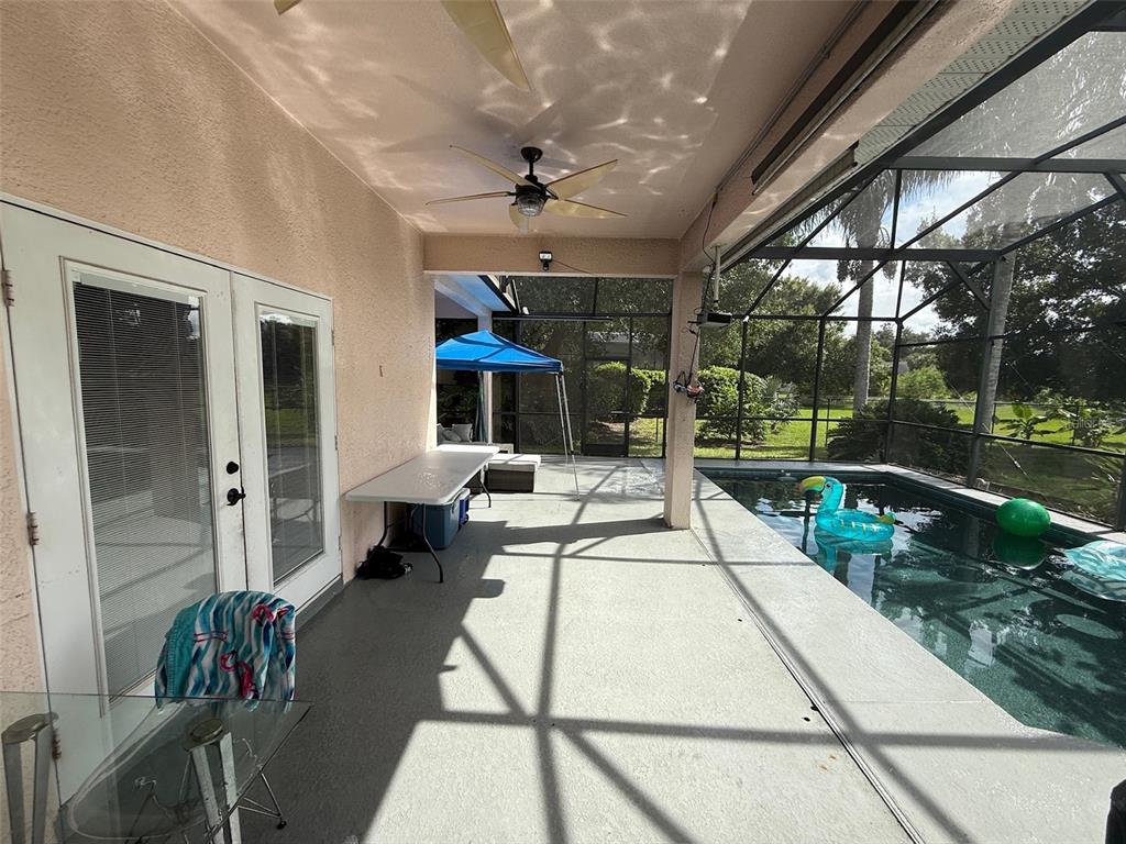 5690 Merlin Way St. Cloud, FL 34772 - Photo 36 of 46 a view of a patio with table and chairs potted plants with wooden floor and fence