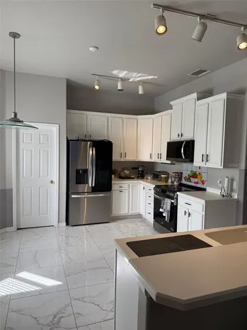 a kitchen with granite countertop a sink a counter top space stainless steel appliances and cabinets