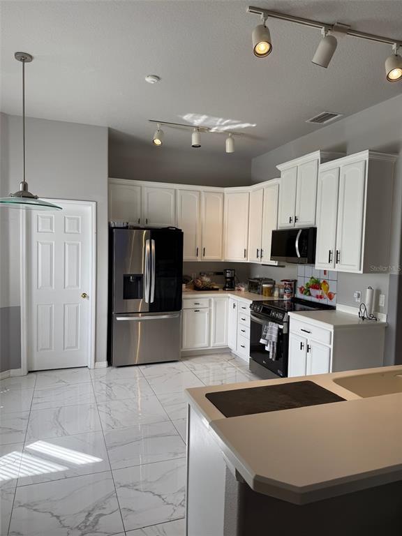 5690 Merlin Way St. Cloud, FL 34772 - Photo 9 of 46 a kitchen with granite countertop a sink a counter top space stainless steel appliances and cabinets