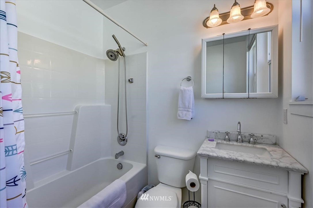 1908 Rucker Avenue Everett, WA 98201 - Photo 19 of 36 a bathroom with a granite countertop sink a toilet and shower