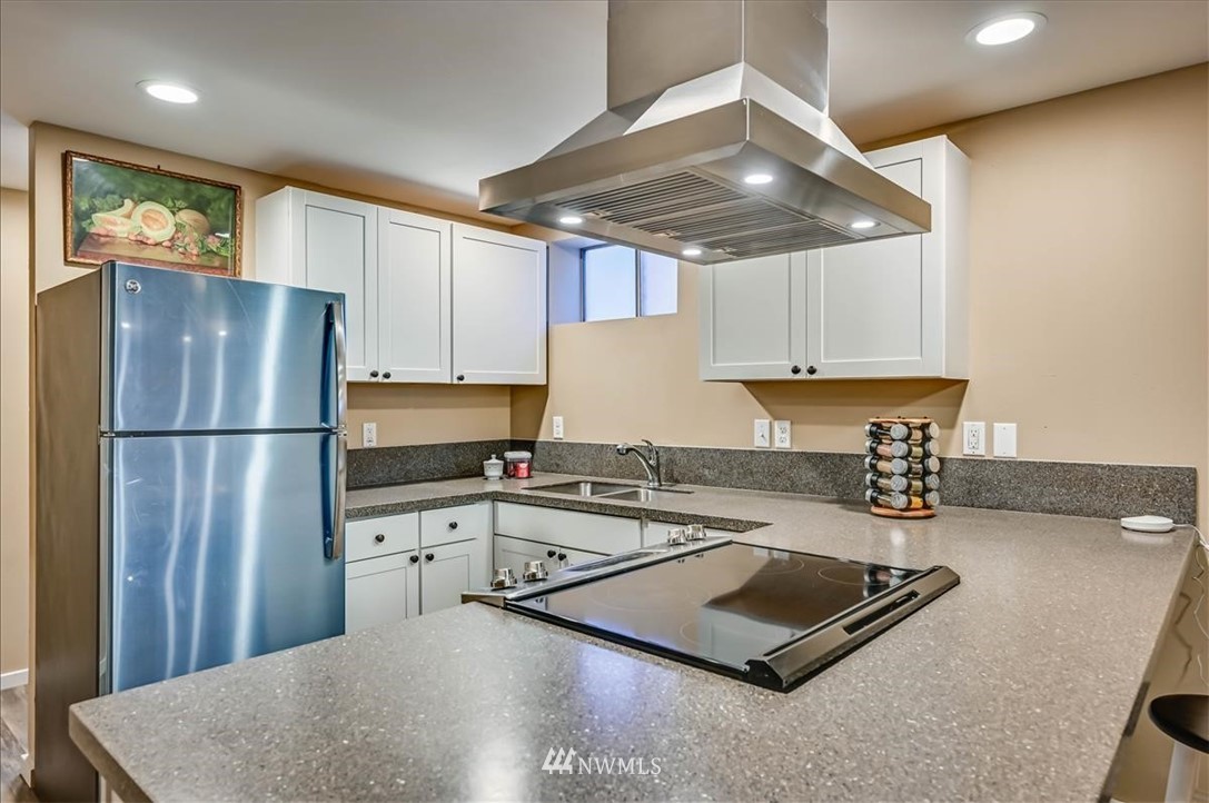 1908 Rucker Avenue Everett, WA 98201 - Photo 24 of 36 a kitchen with granite countertop a refrigerator a sink and white cabinets