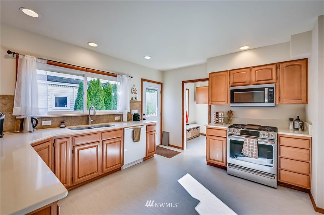 1908 Rucker Avenue Everett, WA 98201 - Photo 6 of 36 a large kitchen with stainless steel appliances granite countertop a stove a sink and a refrigerator