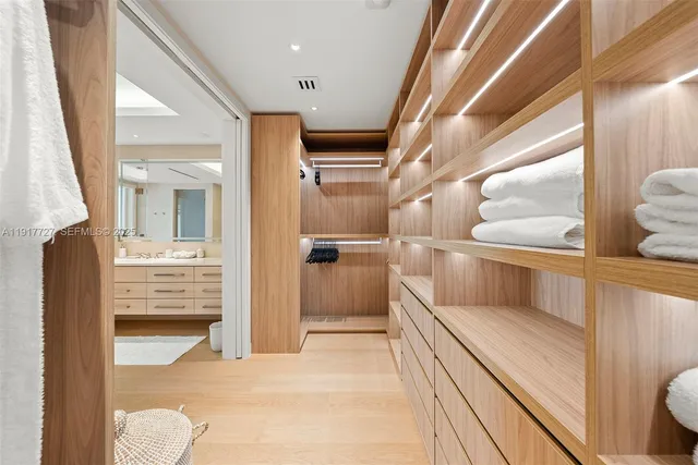 a view of walk in closet with clothes and shoes