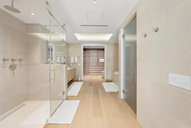 a bathroom with a glass door shower and a sink
