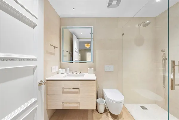 a bathroom with a sink toilet vanity and shower