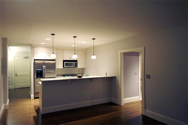 116-128 Rantoul Street, Unit 203 Beverly, MA 01915 - Photo 6 of 15 a kitchen with kitchen island a sink stainless steel appliances and cabinets