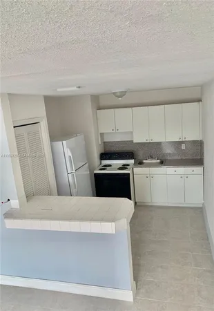 a kitchen with a white cabinets and white appliances