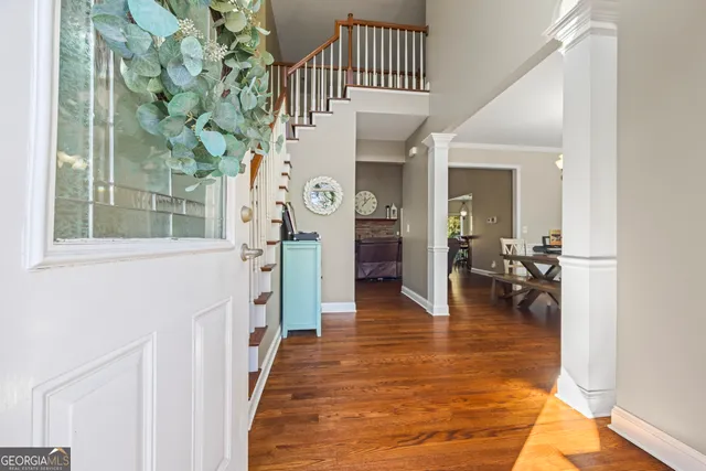 a living room with furniture stairs and a wooden floor