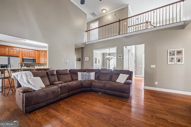 a large kitchen with stainless steel appliances granite countertop a stove top oven a refrigerator a sink and dishwasher with wooden floor