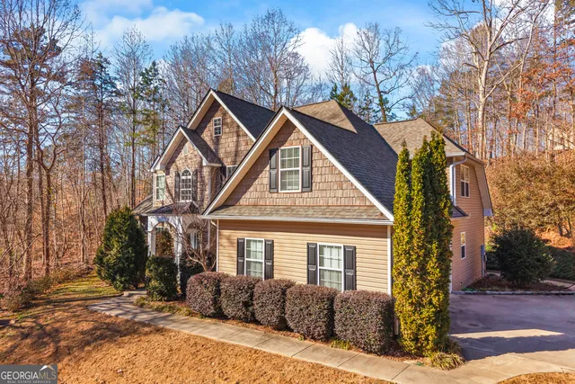 a front view of a house with a yard and trees