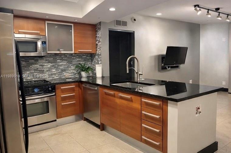 a kitchen with stainless steel appliances granite countertop a sink and a microwave