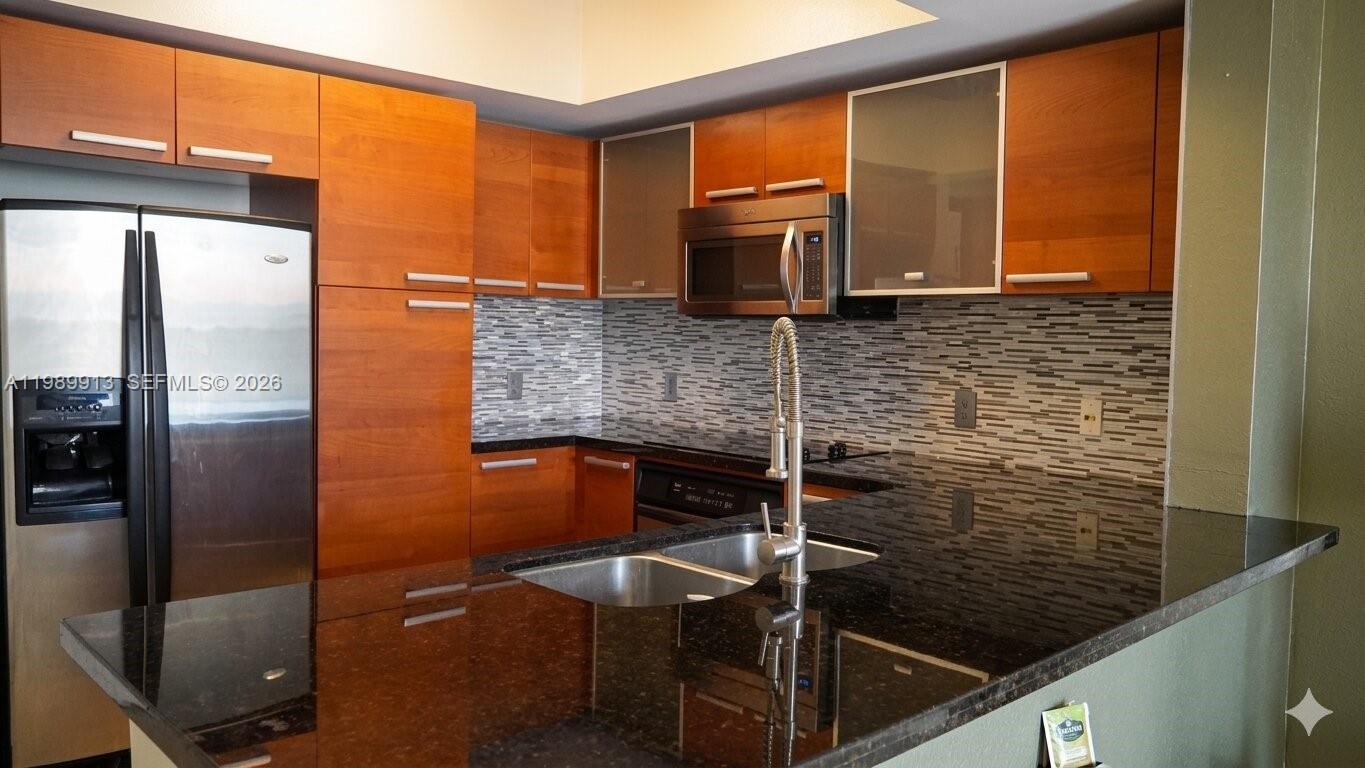 2030 Douglas Road, Unit 414 Coral Gables, FL 33134 - Photo 2 of 15 a kitchen with stainless steel appliances wooden cabinets and a counter top space