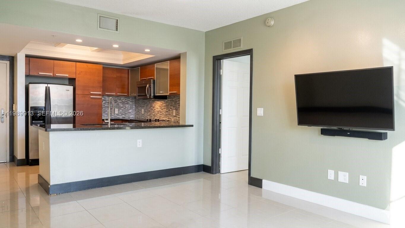 2030 Douglas Road, Unit 414 Coral Gables, FL 33134 - Photo 4 of 15 a living room with a flat screen tv and kitchen view