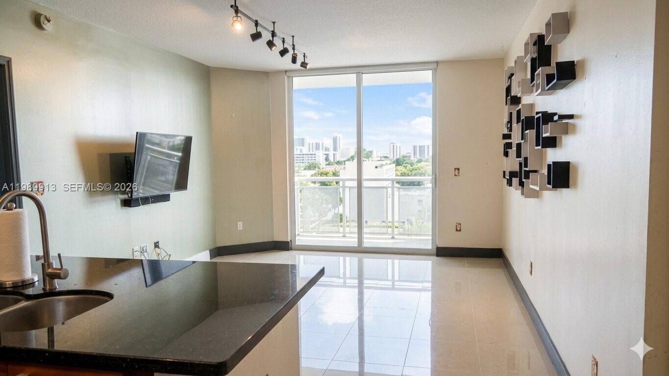 2030 Douglas Road, Unit 414 Coral Gables, FL 33134 - Photo 5 of 15 a living room with furniture and a flat screen tv