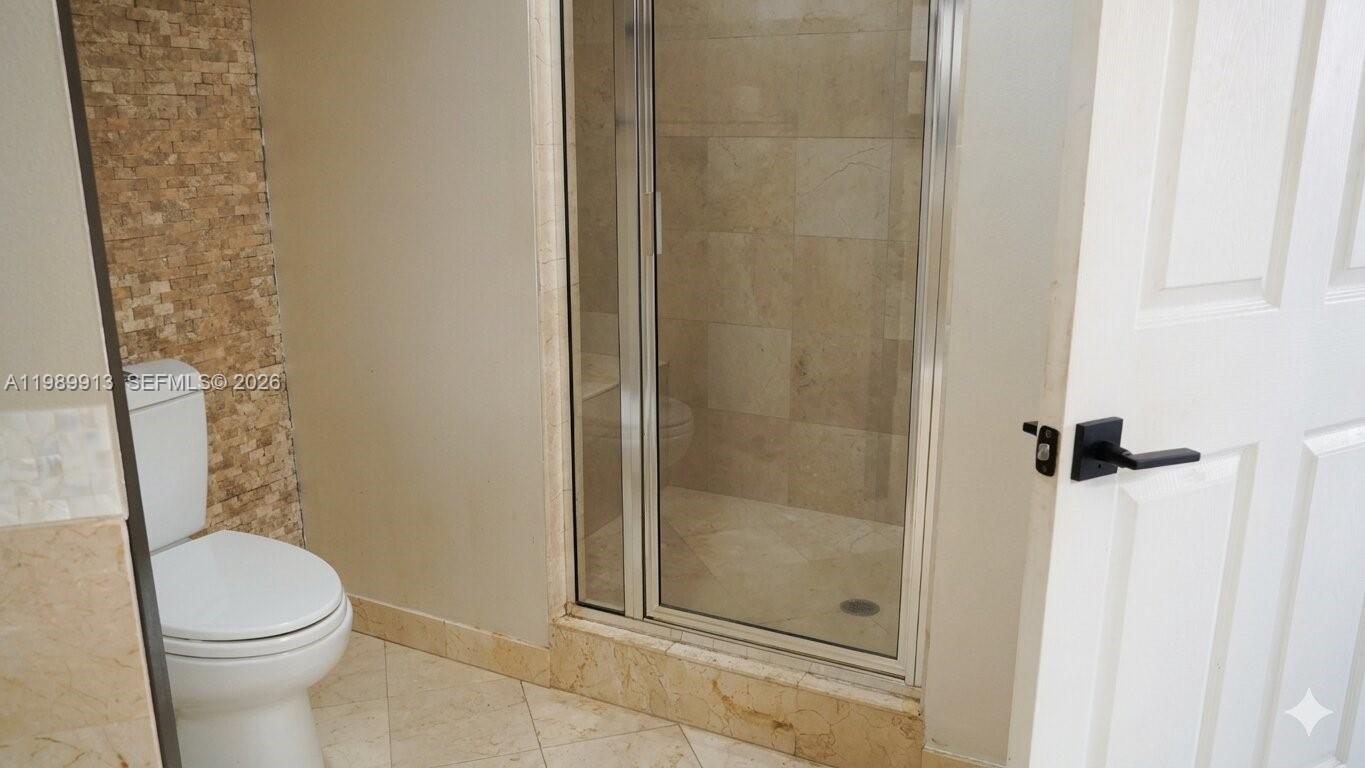 2030 Douglas Road, Unit 414 Coral Gables, FL 33134 - Photo 10 of 15 a white toilet sitting next to a bathroom sink