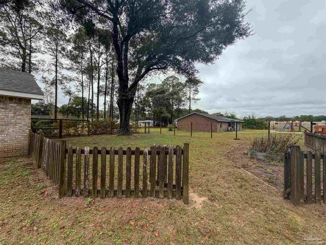 a view of a wooden fence next to a yard