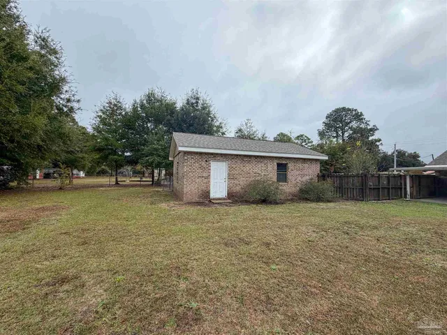 a view of backyard of house with green space
