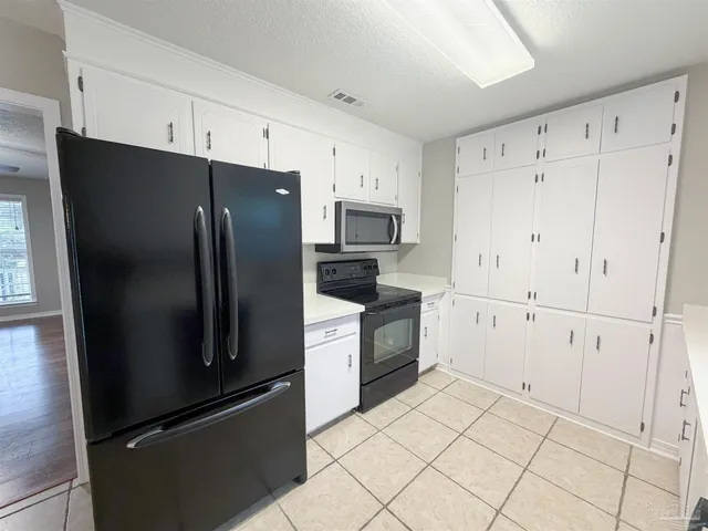a kitchen with white cabinets and stainless steel appliances