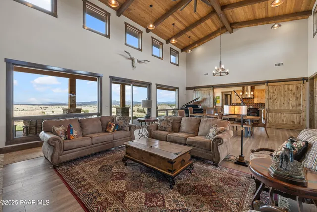 a kitchen with granite countertop a refrigerator a sink dishwasher a dining table and chairs with wooden floor