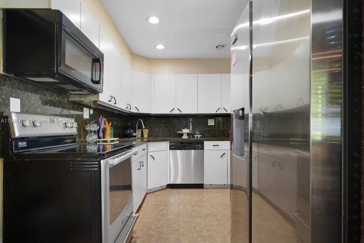 12735 Ixora Road Miami, FL 33181 - Photo 7 of 16 a kitchen with stainless steel appliances granite countertop a refrigerator a stove and a sink