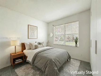 a bedroom with a bed a lamp and a window