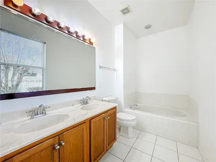 a bathroom with a granite countertop sink a toilet a mirror and shower