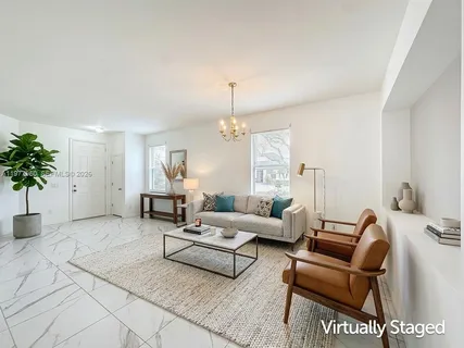 a living room with furniture and potted plants
