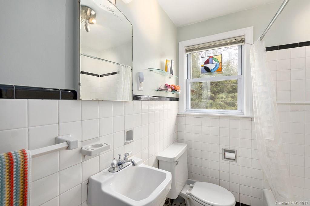 93 School Road Asheville, NC 28806 - Photo 12 of 24 a bathroom with a toilet a sink and mirror