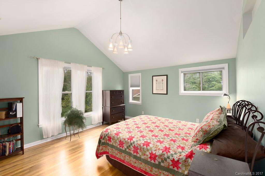 93 School Road Asheville, NC 28806 - Photo 8 of 24 a bedroom with a large bed and a chandelier