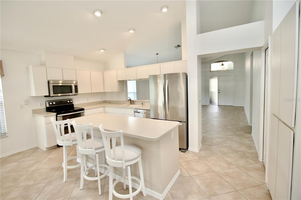 7842 Tenby Court New Port Richey, FL 34655 - Photo 3 of 27 a kitchen with stainless steel appliances granite countertop a refrigerator and a stove top oven