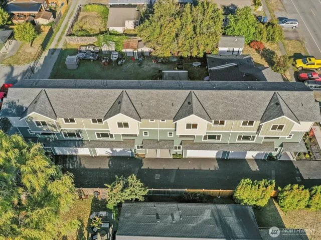 an aerial view of residential houses with outdoor space and trees