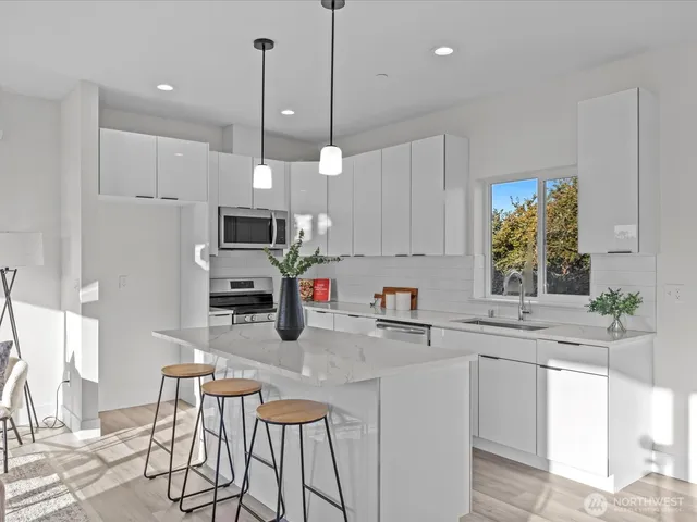 a kitchen with white cabinets and stainless steel appliances