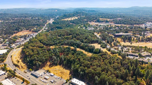 an aerial view of residential houses with outdoor space and trees