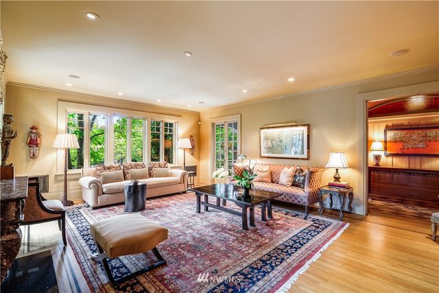 a dining room with furniture and large windows