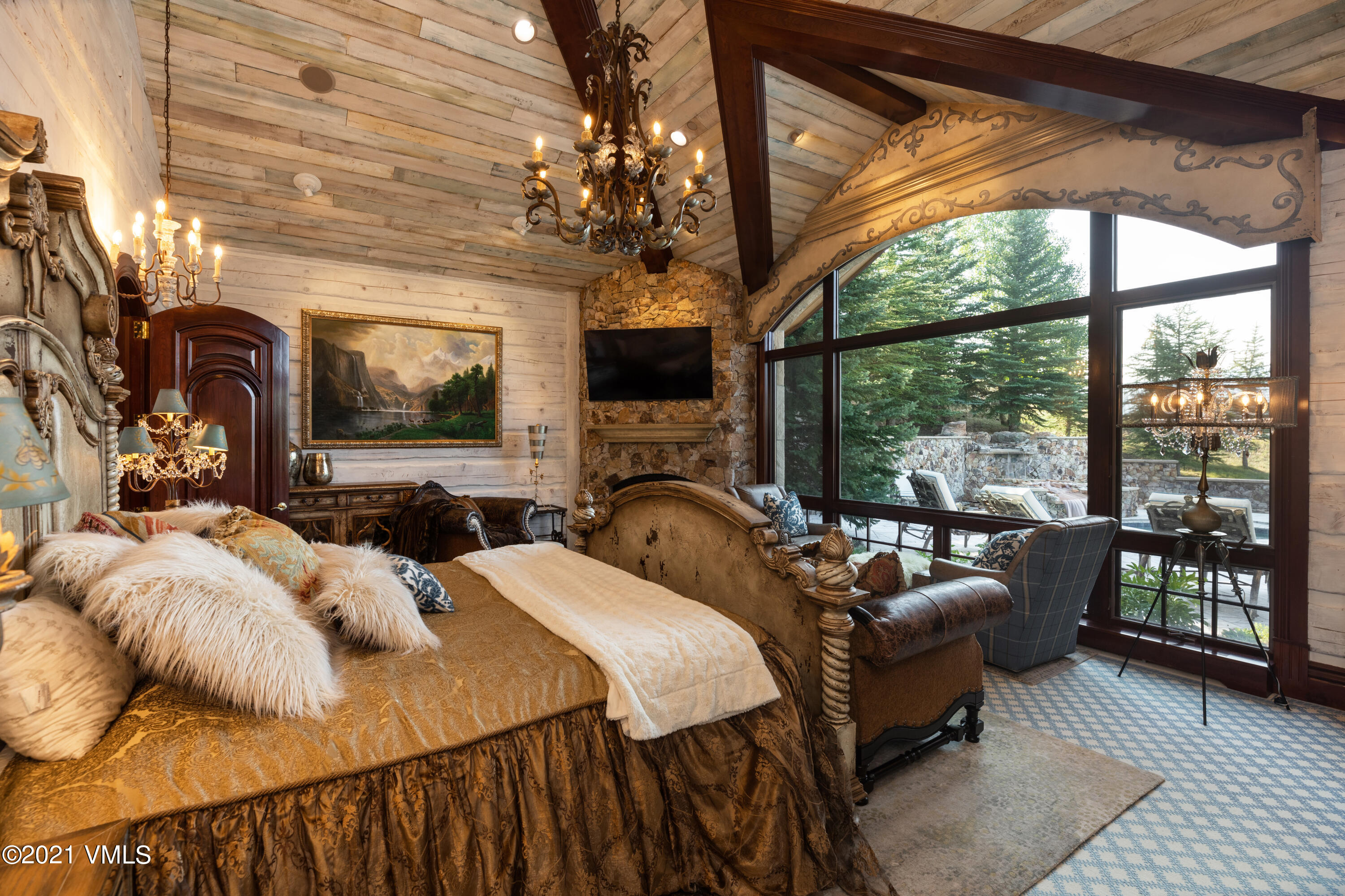 245 Casteel Ridge Edwards, CO 81632 - Photo 15 of 21 a bedroom with furniture a chandelier and a fireplace