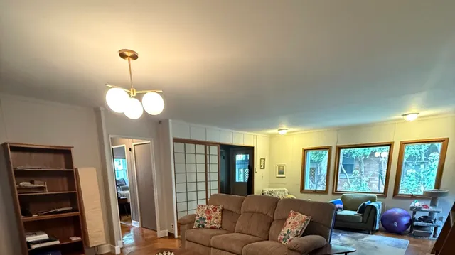 a living room with furniture chandelier and large windows